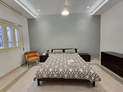 a bedroom with a bed and a chair in it at Downtown Living Boutique Apartments in Amman