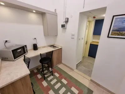 a small kitchen with a counter and a microwave at Downtown Living Boutique Apartments in Amman
