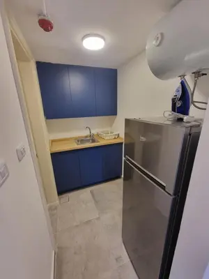 a kitchen with blue cabinets and a stainless steel refrigerator at Downtown Living Boutique Apartments in Amman