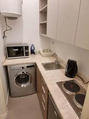 a kitchen with a washing machine and a sink at Downtown Living Boutique Apartments in Amman
