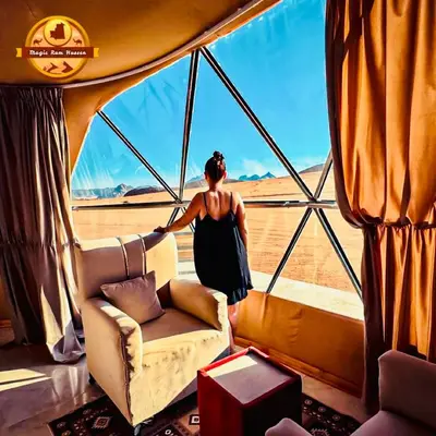 a woman standing in a room with a window at MAGIC RUM lUXURY HUSSEN in Wadi Rum