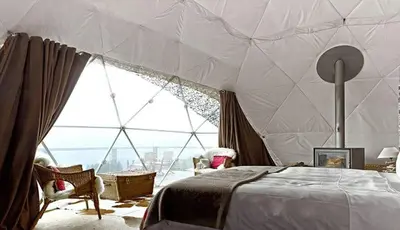 a bedroom with a tent with a large window at MAGIC RUM lUXURY HUSSEN in Wadi Rum