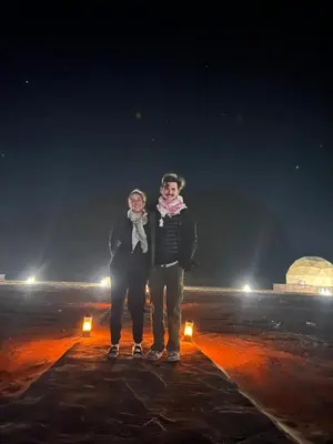 two people standing in the snow at night at MAGIC RUM lUXURY HUSSEN in Wadi Rum