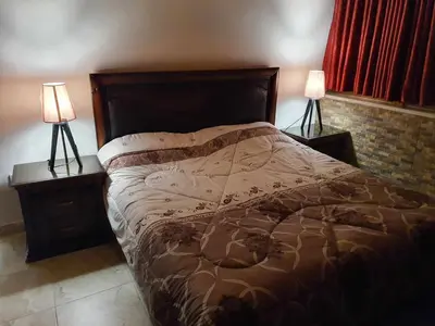 a bedroom with a bed with two lamps on tables at Suad Apartment in Amman