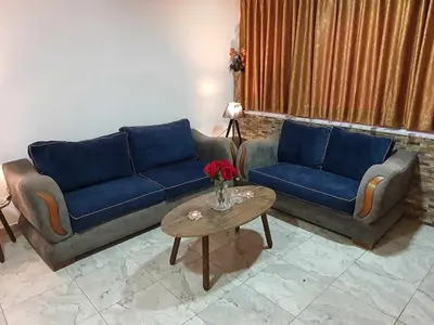 a living room with two blue couches and a table at Suad Apartment in Amman