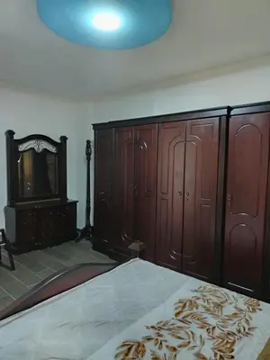 a bedroom with wooden cabinets and a bed and a mirror at شقة فاخرة مع مطل luxerious with nice view in Amman