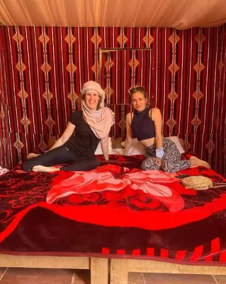 a man and a woman sitting on a bed at Wadirum winter in Wadi Rum