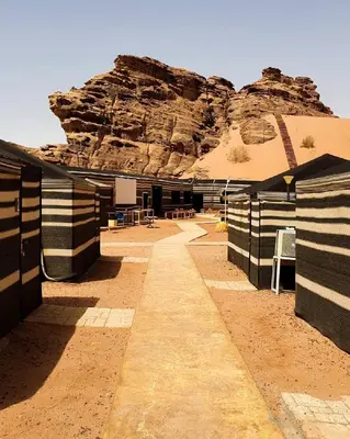 a building in the desert with a mountain in the background at Wadirum winter in Wadi Rum