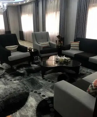 a living room with couches and tables and windows at شقق المومني in Amman