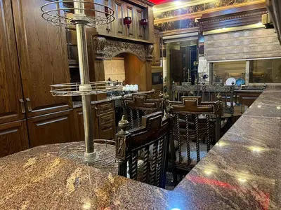 a bar in a restaurant with a counter and chairs at شقق المومني in Amman