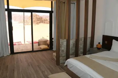 a bedroom with a bed and a large window with a view at Imagination Luxury Camp in Disah