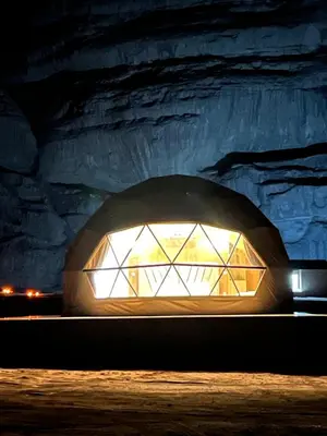 a large window in a stone cave at night at Golden Gate Luxury Camp in Wadi Rum