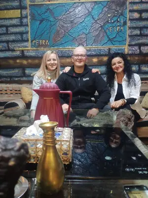 a man and two women sitting on a table at Petra Anas House in Wadi Musa