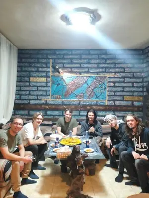 a group of people sitting around a table in a room at Petra Anas House in Wadi Musa