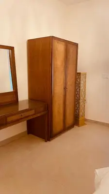 a bedroom with a wooden cabinet and a mirror at Saraya locanda in Al Salt