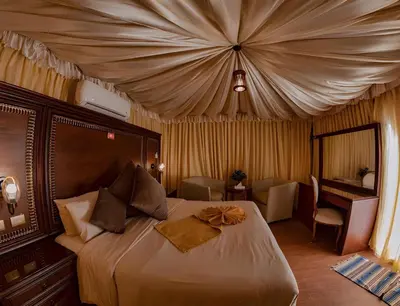 a bedroom with a large bed with a canopy at Shebara Camp Wadi Rum in Wadi Rum