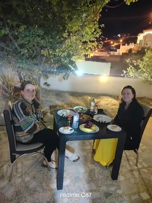 two women sitting at a table with food on it at Marvel Hotel Apartments in Wadi Musa