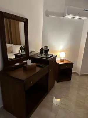 a bathroom with a vanity with a mirror and a lamp at Marvel Hotel Apartments in Wadi Musa