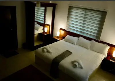 a bedroom with a large white bed with a mirror at Marvel Hotel Apartments in Wadi Musa