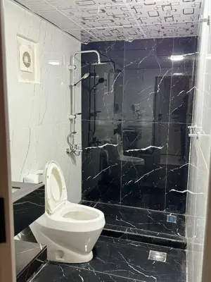a bathroom with a toilet and a glass shower at Rum Plaza Luxury Camp in Wadi Rum