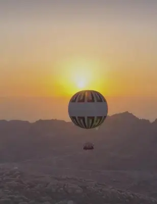 a hot air balloon flying in the sky at sunset at Little Green Farm in Wadi Musa