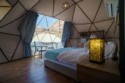 a bedroom with a tent with a bed and a table at Shell Luxury Camp in Wadi Rum