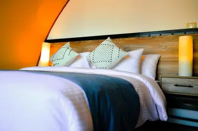 a bedroom with a bed with white sheets and pillows at Shell Luxury Camp in Wadi Rum