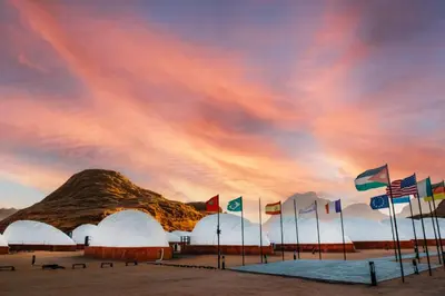 a group of flags in front of a mountain at Shell Luxury Camp in Wadi Rum