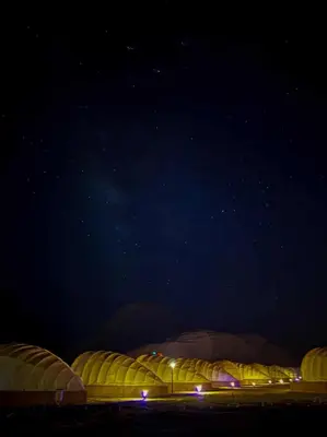 a row of domed buildings at night with the sky at Shell Luxury Camp in Wadi Rum