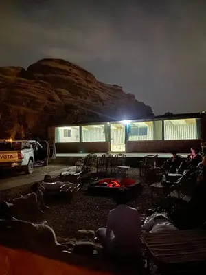 a group of people sitting on chairs in front of a building at Mira Bedouin Camp in Wadi Rum