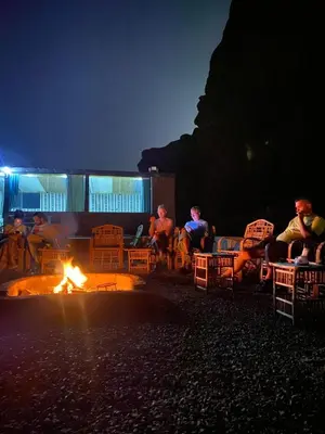 a group of people sitting around a fire at night at Mira Bedouin Camp in Wadi Rum
