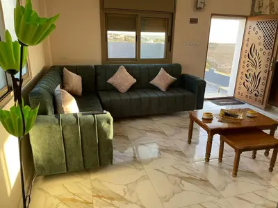 a living room with a green couch and a table at مزرعة الشفق in Ad Dimnah