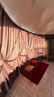 a tent with two chairs and a table in a room at Madar Camp, Wadi Rum in Wadi Rum
