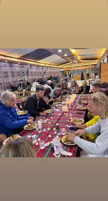 a group of people sitting at a long table eating food at Madar Camp, Wadi Rum in Wadi Rum
