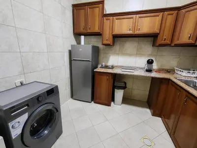a kitchen with a refrigerator and a washing machine at CMK Housing in Madaba