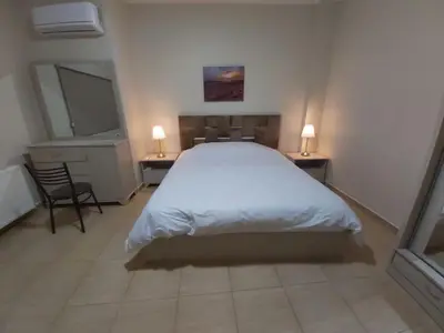 a bedroom with a bed and two tables and a mirror at CMK Housing in Madaba