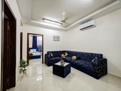 a living room with a blue couch and a table at ENG-Murjan Apartment in Aqaba