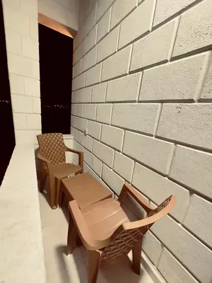a room with two benches and a brick wall at ENG-Murjan Apartment in Aqaba