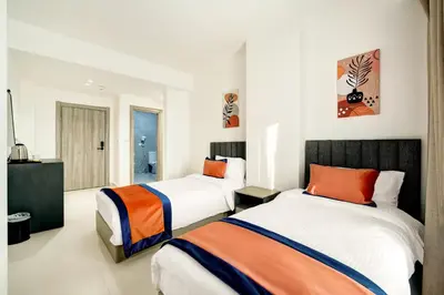 a bedroom with two beds and a television in it at The Loft hotel By FHM in Aqaba