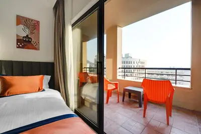 a bedroom with a bed and a balcony with a view at The Loft hotel By FHM in Aqaba
