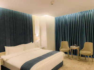 a hotel room with a bed and two chairs at Rival Hotel Amman in Amman