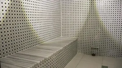 a white wall with a bench in a shower at Rival Hotel Amman in Amman