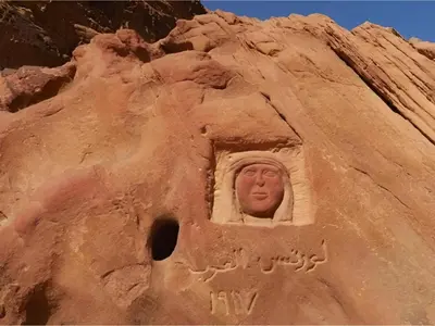 a statue of a face in a rock wall at The bubble camp in Wadi Rum