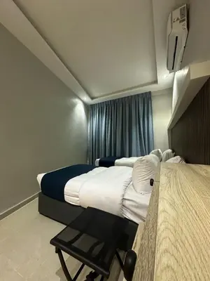 a hotel room with two beds and a window at Aladnan hotel in Aqaba