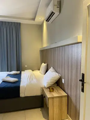 a hotel room with a large bed and a table at Aladnan hotel in Aqaba
