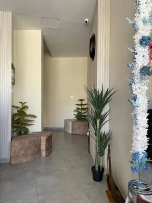 a hallway with two benches and plants in a building at Aladnan hotel in Aqaba