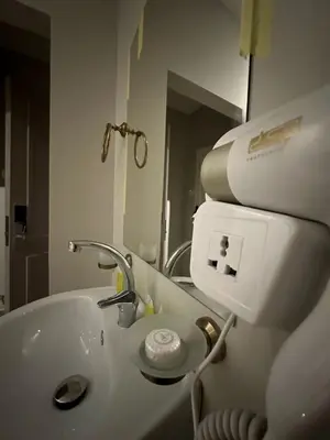 a white bathroom with a sink and a mirror at Aladnan hotel in Aqaba
