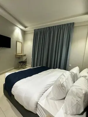 a bedroom with a large white bed with a window at Aladnan hotel in Aqaba