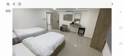 a white room with two beds and a kitchen at Petra Desert Hotel in Wadi Musa