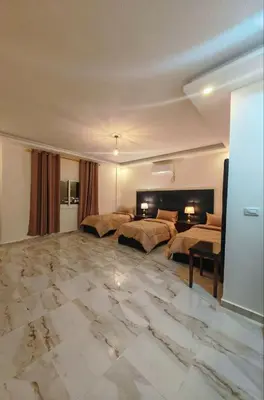 a large room with two beds and a marble floor at iHome Petra in Wadi Musa